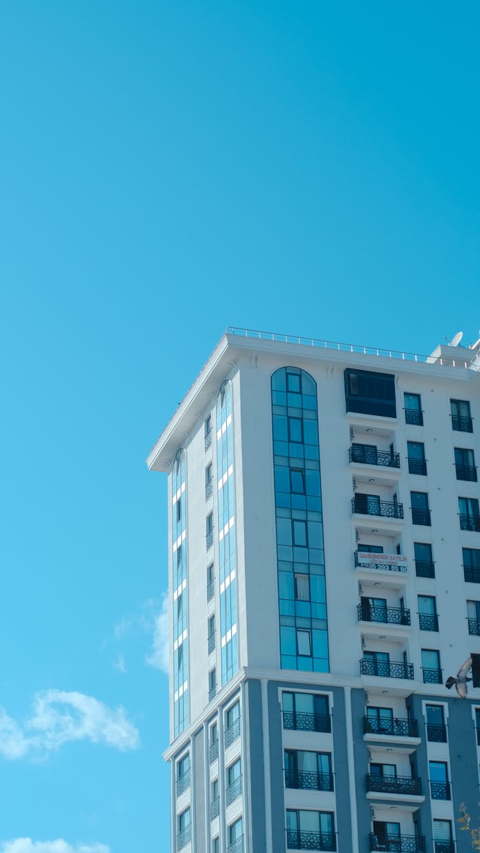 Contemporary apartment building facade with blue sky, showcasing modern architecture.